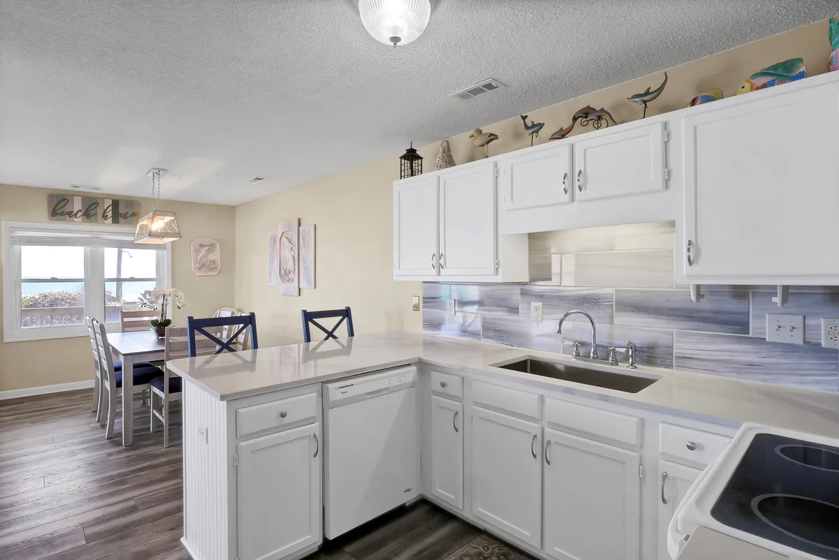 A spacious kitchen and dining area featuring a kitchen island, dining table, and decorative shelves. The warm ambiance suggests a space designed for family gatherings, shared meals, and entertaining, with thoughtful details that imply a self-contained, comfortable living setup.